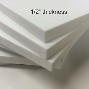 Puede incluir: Primer plano de tres tableros de espuma blanca apilados uno encima del otro. El tablero superior tiene el texto "1/2" thickness" impreso en &eacute;l.