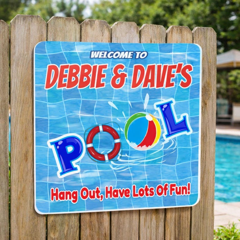 personalized pool sign mounted on wooden fence near backyard swimming pool with beach ball and lifebuoy graphics