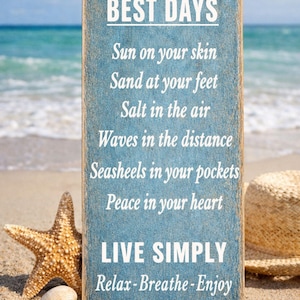 beach decor sign displayed on sand with ocean waves starfish and shells