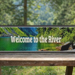 lifestyle image of river sign displayed on outdoor wooden bench with natural setting