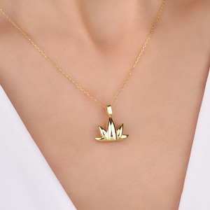 Può includere: Una collana con catena d'oro e un delicato ciondolo a forma di fiore di loto.