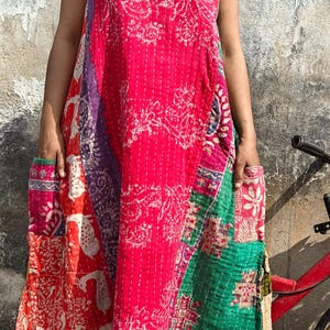 Può includere: Abito senza maniche patchwork dai colori vivaci. L'abito presenta un mix di tessuti rossi, verdi, viola e fantasia. L'abito ha tasche e una silhouette ampia e fluida, perfetto per l'abbigliamento casual.