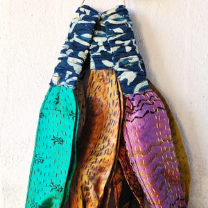 Peut inclure: Ensemble de bandeaux en tissu faits &agrave; la main, aux couleurs vives. Les bandeaux pr&eacute;sentent divers motifs et couleurs, notamment le turquoise, le jaune, le violet et le bleu. Chaque bandeau est orn&eacute; de coutures complexes. Une &eacute;tiquette avec le texte "MADHUBANI CRAFT HANDMADE" est attach&eacute;e.