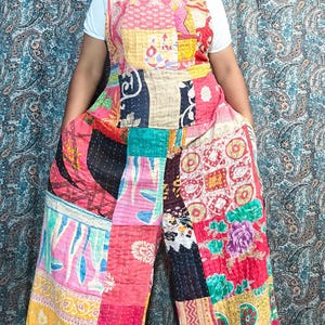 Puede incluir: Mono patchwork colorido con top de peto y perneras anchas. La prenda está hecha de varios parches de tela en tonos rosa, rojo, amarillo y azul. Diseño único y llamativo.