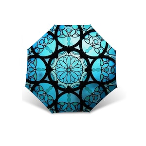 Puede incluir: Un paraguas azul y negro con un patrón de vitral.