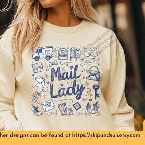 Peut inclure: Un sweat-shirt jaune clair avec un motif graphique bleu et blanc d'objets li&eacute;s au courrier, notamment un camion postal, des bo&icirc;tes aux lettres, des enveloppes et une cl&eacute;. Le texte "Mail Lady" est pr&eacute;sent&eacute; en lettres bleues.