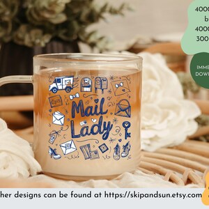 Peut inclure: Une tasse en c&eacute;ramique blanche avec un motif bleu et noir repr&eacute;sentant le texte "Mail Lady" et diverses illustrations sur le th&egrave;me du courrier. La tasse est remplie d'un liquide brun clair.
