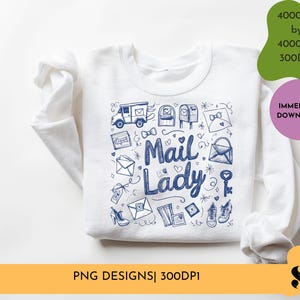 Peut inclure: Sweat-shirt blanc avec un motif bleu et blanc repr&eacute;sentant le texte "Mail Lady" entour&eacute; d'illustrations sur le th&egrave;me du courrier, notamment des bo&icirc;tes aux lettres, des enveloppes et un camion de livraison.