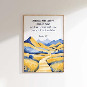 May include: A framed art print featuring a watercolor landscape with yellow and blue mountains, a winding path, and the text "Befiehl dem Herrn deinen Weg, und vertraue auf ihn, so wird er handeln. Psalm 37.5".