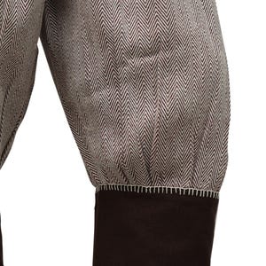 May include: Close-up of the cuff of a brown and white herringbone patterned jacket with a brown fabric cuff.