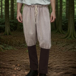May include: A pair of brown and white patterned pants with a drawstring waist and dark brown cuffs. The pants are made of a soft, textured fabric.