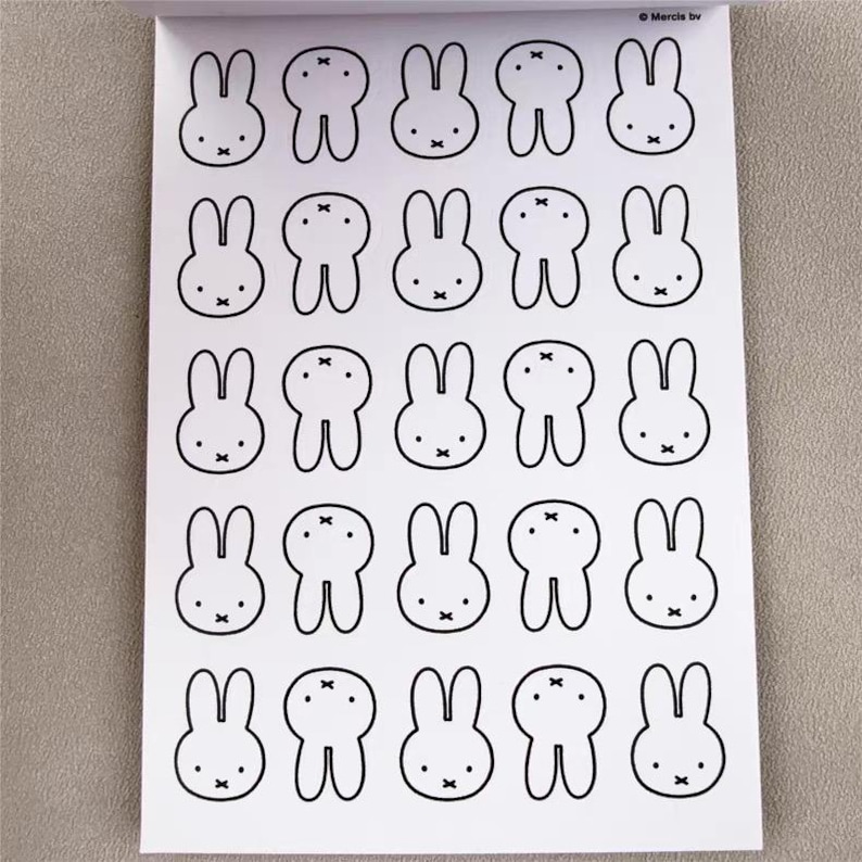 May include: A sheet of stickers featuring a repeating pattern of black and white cartoon bunny faces. Each bunny has long ears, a small nose, and a simple bow tie. The stickers are on a white background.
