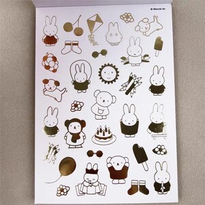 May include: A sheet of stickers featuring gold foil illustrations of cartoon bunnies, bears, and other cute objects. The stickers include a kite, cherries, a sun, a cake, and an ice cream bar. The stickers are on a white background.