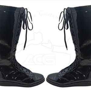 May include: Pair of glossy black knee-high boots with lace-up closures. The boots have a shiny patent leather appearance and a flat sole. The laces are black and extend up the front of the boots.