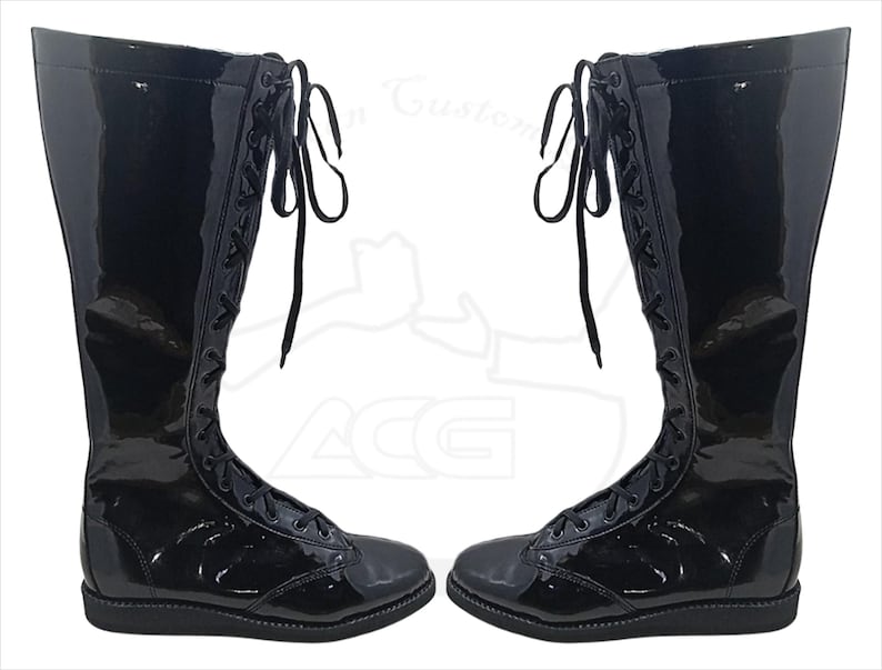 May include: Pair of glossy black knee-high boots with lace-up closures. The boots have a shiny patent leather appearance and a flat sole. The laces are black and extend up the front of the boots.