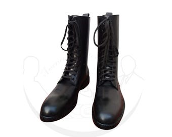 May include: A pair of black leather combat boots with a lace-up design. The boots have a rounded toe and a sturdy sole. The boots are shown against a white background.