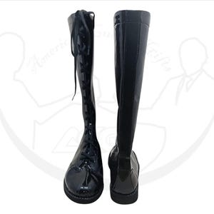 May include: Pair of black knee-high boots with a glossy finish. One boot features a lace-up design, while the other showcases a smooth, streamlined appearance. The boots have a rounded toe and a low heel, suitable for various outfits.