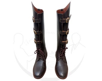 May include: A pair of brown leather riding boots with gold buckles and laces. The boots have a pointed toe and a tall shaft.