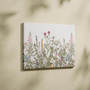 May include: A canvas print featuring a colourful floral design with a variety of flowers and plants, including pink, purple, yellow, and blue flowers.