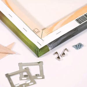 Puede incluir: Una pieza de arte en lienzo ensamblada con un borde verde y gris, junto con herrajes met&aacute;licos para colgar, tornillos y escuadras. Tambi&eacute;n hay una estrella de madera. El lienzo est&aacute; estirado sobre un marco de madera.
