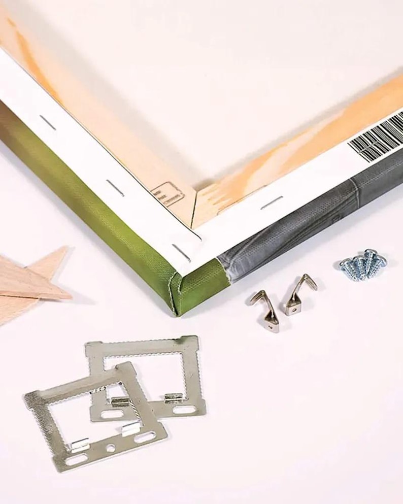 Puede incluir: Una pieza de arte en lienzo ensamblada con un borde verde y gris, junto con herrajes met&aacute;licos para colgar, tornillos y escuadras. Tambi&eacute;n hay una estrella de madera. El lienzo est&aacute; estirado sobre un marco de madera.