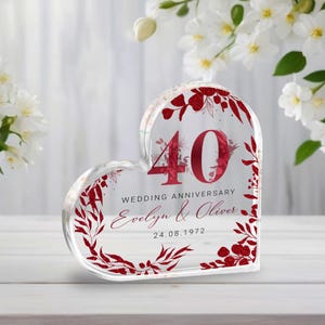 Może przedstawiać: Przezroczysta akrylowa pamiątka w kształcie serca z czerwonymi kwiatowymi akcentami. Upamiętnia 40. rocznicę ślubu, z liczbą "40", słowami "Wedding Anniversary", imionami "Evelyn & Oliver" i datą "24.08.1972".