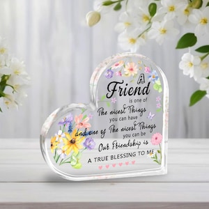 May include: A heart-shaped clear acrylic block with floral accents and the text "A Friend is one of The nicest Things you can have and one of The nicest Things you can be. Our Friendship is A TRUE BLESSING TO ME."