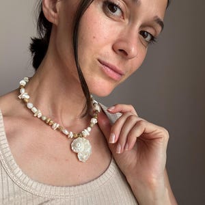 A layered necklace inspired by the ocean featuring freshwater pearls, shells, jasper and mother of pearl