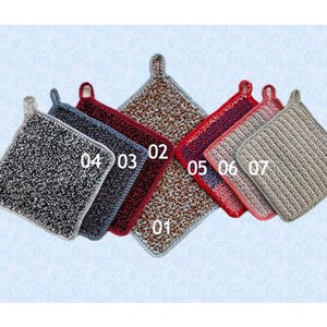 Op de afbeelding: Een verzameling van zeven vierkante, getextureerde pannenlappen in verschillende kleuren, waaronder zwart, blauw, rood en beige. Elke pannenlap heeft een lus om op te hangen en is genummerd.