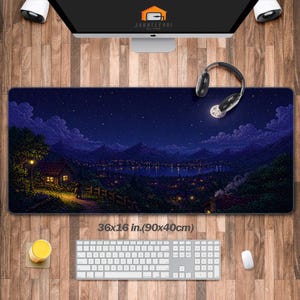 May include: A rectangular desk mat with a pixelated night scene featuring a starry sky, mountains, and a town with lights. The mat measures 36x16 inches (90x40cm). A keyboard, mouse, and headphones are visible.