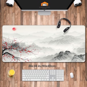 May include: A white and gray mountain landscape with a red cherry blossom tree in the foreground. The design is printed on a black mouse pad with a white border. The mouse pad measures 36x16 inches (90x40 cm).