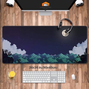May include: A rectangular desk mat with a pixelated landscape design featuring mountains, clouds, and a starry night sky. The mat measures 36 x 16 inches. A keyboard, mouse, and headphones are on the wooden desk.
