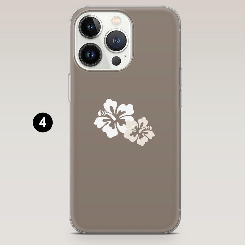 May include: A phone case with a taupe background and a white floral design. The case has a clear border and a camera cutout. The floral design features two white hibiscus flowers.