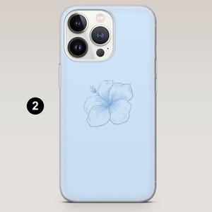 May include: A light blue phone case featuring a detailed, light blue hibiscus flower design. The case has a clear border and a camera cutout. The phone case is designed to fit a smartphone.