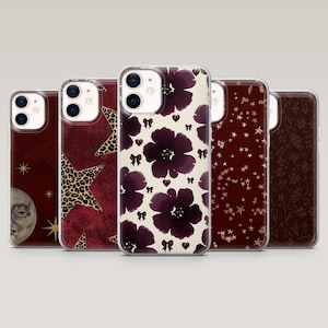 May include: A collection of five phone cases with various designs. The cases feature patterns such as leopard print stars, burgundy floral, and a celestial theme with a moon and stars. The cases are in a row, showcasing their unique designs.