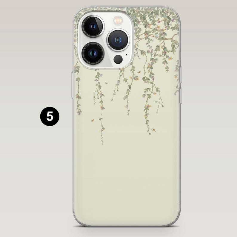 Op de afbeelding: Telefoonhoesje met een bloemenontwerp. De hoes heeft een lichtbeige achtergrond met een delicaat patroon van hangende wijnranken, bladeren en kleine bloemen in groen- en roze tinten. De hoes heeft een transparante rand en een drievoudige cameralens.