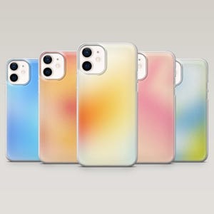May include: Five mobile phone cases with a gradient design in shades of blue, orange, yellow, pink, and green. Each case has a clear border and a camera cutout.