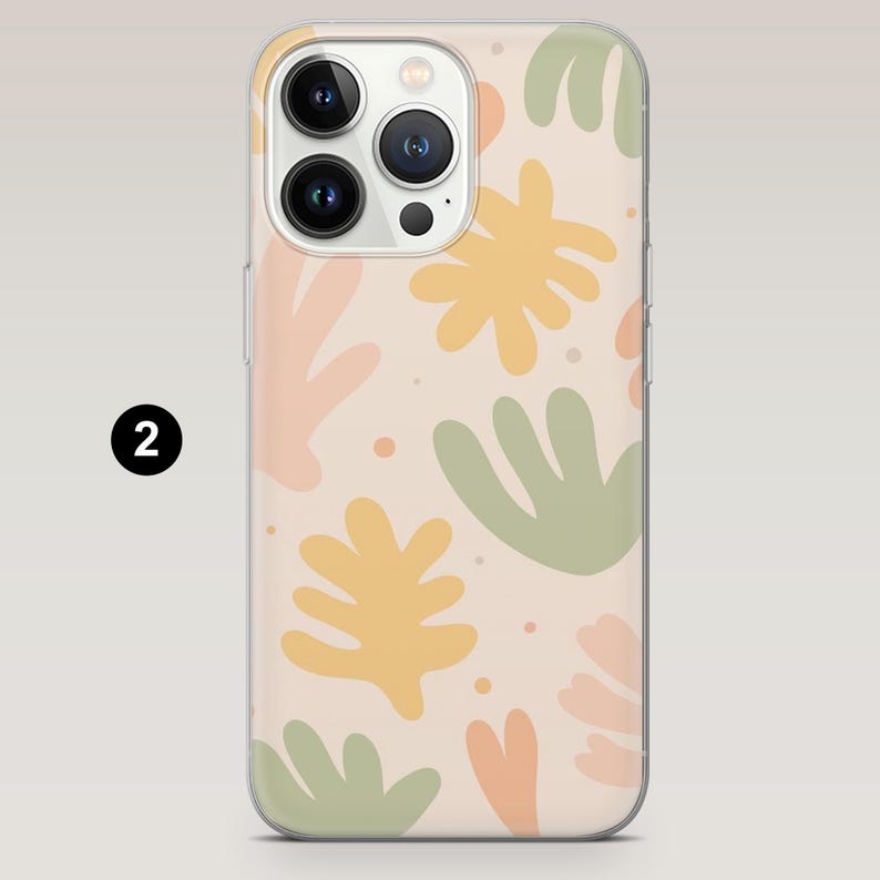 May include: Clear phone case with a colorful abstract design. The case features a pattern of yellow, green, and peach-colored shapes on a beige background. The phone case has a clear border and a camera cutout.