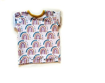 May include: A white short-sleeved t-shirt with a colourful rainbow pattern. The shirt has a yellow trim around the neckline.