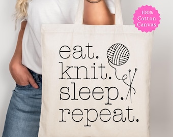 May include: A natural-colored cotton canvas tote bag featuring the black printed text 'eat. knit. sleep. repeat.' alongside a graphic illustration of a ball of yarn and two knitting needles. A pink circular badge states '100% Cotton Canvas'.