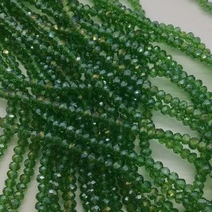 Peut inclure: Un brin de perles de verre facettées vertes. Les perles sont petites et ont un léger reflet iridescent.