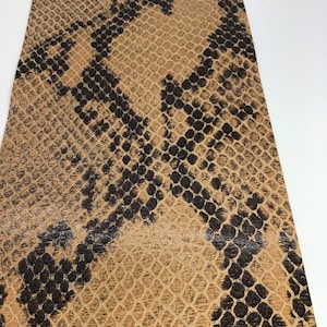 Peut inclure: Faux cuir couleur tan avec un motif de peau de serpent noir.