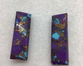May include: Two rectangular pieces of purple, blue, and gold patterned stone. The stones have a rough, natural texture.