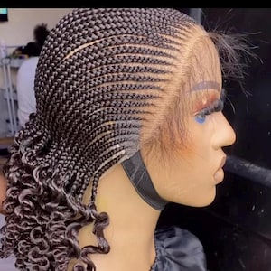 May include: A braided wig with a lace front. The braids are tightly woven across the top of the head, transitioning into loose, curly strands at the nape of the neck. The wig is designed to mimic a natural hairline.