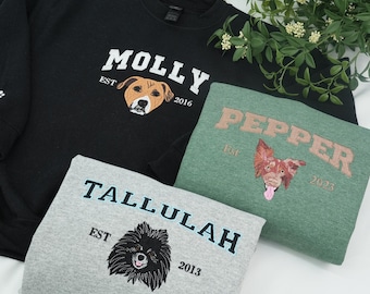 May include: Three sweatshirts with custom dog portraits. A black sweatshirt features "MOLLY" with a dog illustration and "EST 2016". A green sweatshirt has "PEPPER" and "EST 2023". A gray sweatshirt displays "TALLULAH" and "EST 2013".
