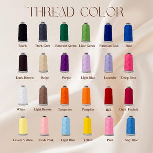 May include: A color chart displaying a variety of thread colors. The chart includes shades like black, dark grey, emerald green, lime green, Prussian blue, and blue. Additional colors include dark brown, beige, purple, light lilac, and lavender.
