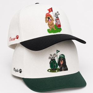 Puede incluir: Dos gorras de béisbol blancas con bordados. La gorra superior tiene visera negra y muestra un perro dorado con gorra roja junto a una bolsa de golf. La gorra inferior tiene visera verde y un perro negro con gorra verde junto a una bolsa.