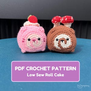 May include: Two crocheted roll cakes, one pink with a strawberry and cream topping, the other brown with mushroom accents. The cakes have cute faces. Text on a purple background reads "PDF CROCHET PATTERN Low Sew Roll Cake."