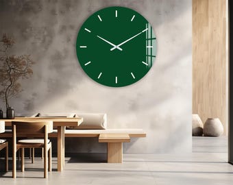 May include: A modern, round wall clock with a deep green face and white hands and markers. The clock is mounted on a textured gray wall in a minimalist interior setting. The clock's hands indicate the time.