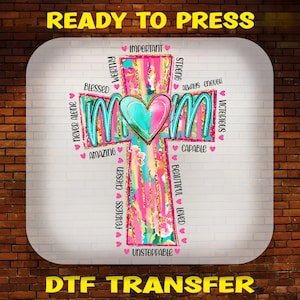 May include: A pink and blue cross with the word "MOM" in the center. The cross is surrounded by words like "blessed", "worthy", "strong", "capable", "unstoppable", and "victorious".